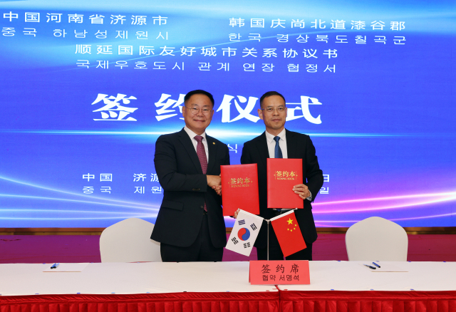 김재욱 칠곡군수(왼쪽)와 친바오젠 제원시장이 국제우호도시 협약서에 서명하고 기념촬영을 하고 있다. 칠곡군 제공