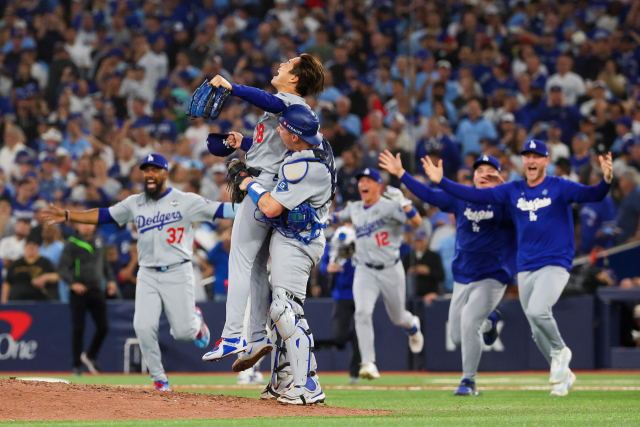 LA 다저스의 야마모토 요시노부가 2일 캐나다에서 열린 MLB 월드시리즈 7차전에 등판해 토론토 블루제이스의 공세를 막고 승리, 우승을 확정짓자 포수 윌 스미스가 마운드로 올라가 번쩍 들어주며 기쁨을 나누고 있다. 연합뉴스