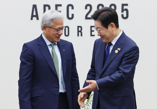 이재명 대통령이 지난달 31일 APEC 정상회의장인 경주화백컨벤션센터에서 젠슨 황 엔비디아 최고경영자와 면담 전 기념 촬영을 마친 뒤 자리를 안내하고 있다. 연합뉴스