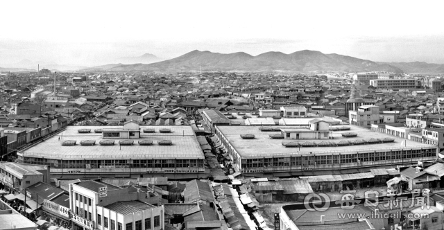 1967년 11월 서문시장 주변 풍경. 시장 너머 기와집 사이로 초가집도 보인다. 왼쪽 멀리 언덕 위로 보이는 건물은 1966년 완공된 내당성당이다. 사진=매일아카이빙센터