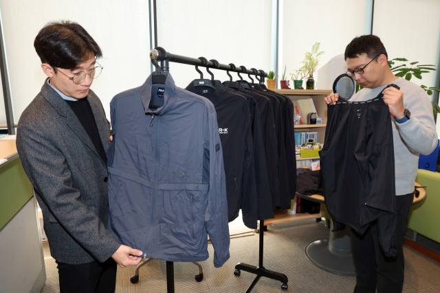 한국소비자원이 5일 정부세종청사 공정거래위원회 기자실에서 소비자 선호도가 높은 러닝 재킷 8개 제품에 대한 품질 및 안전성 등을 시험·평가한 비교정보를 발표했다. 사진은 관계 직원이 시험 제품을 살펴보는 모습. 연합뉴스