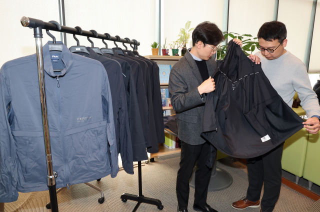 한국소비자원이 5일 정부세종청사 공정거래위원회 기자실에서 소비자 선호도가 높은 러닝 재킷 8개 제품에 대한 품질 및 안전성 등을 시험·평가한 비교정보를 발표했다. 사진은 관계 직원이 시험 제품을 살펴보는 모습. 연합뉴스