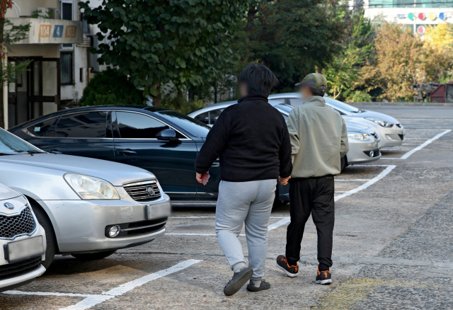 5일 오전 대구 북구의 한 아파트에서 발달장애인 나현(23·가명) 씨가 치료센터로 가기위해 아버지와 손을 잡고 이동하고 있다. 김영진 기자 kyjmaeil@imaeil.com