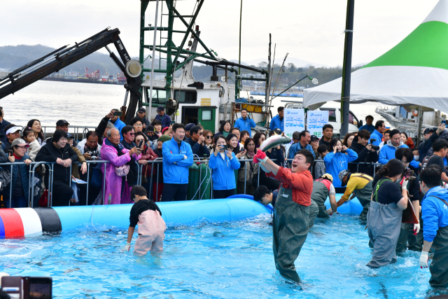 죽변항 수산물축제에 참가한 관광객이 활어를 잡아 올리고 있다. 울진군 제공