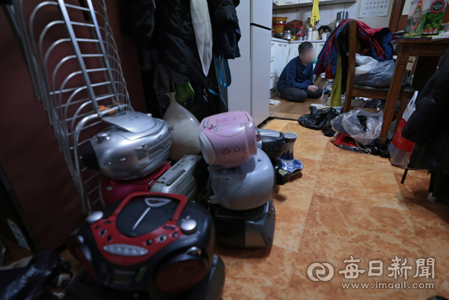 7일 대구 남구의 한 주택에서 발달장애인 상훈(46·가명) 씨가 라디오들 사이에 앉아 있다. 상훈 씨는 라디오에 집착해 집 안 곳곳에 크기와 모양이 다른 라디오 수십 대를 쌓아두고 있다. 김영진 기자 kyjmaeil@imaeil.com