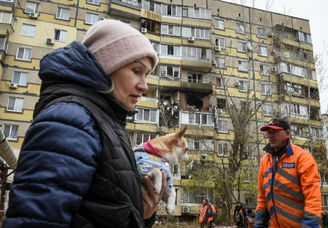 8일(현지시간) 러시아의 드론 공격으로 피해를 입은 우크라이나 드니프로의 한 아파트 앞을 현지 주민이 지나가고 있다. 로이터 연합뉴스