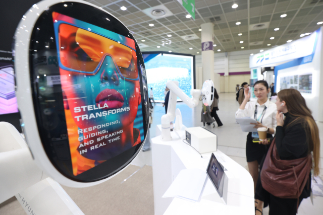 지난달 21일 서울 강남구 코엑스에서 열린 KES 2025(한국전자전)에서 외국인 참관객이 AI로봇에 대해 질문하고 있다. 연합뉴스