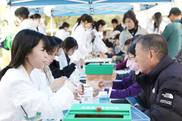 영남이공대 간호학과 학생이 행사에 참여한 지역 주민의 혈당을 체크하고 설명하고 있다. 영남이공대 제공