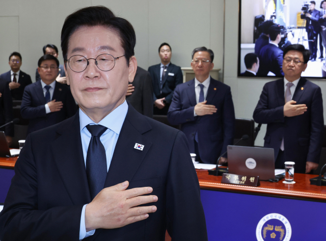 이재명 대통령과 정성호 법무부 장관(뒷줄 가운데)이 11일 용산 대통령실에서 열린 국무회의에서 국기에 경례하고 있다. 연합뉴스