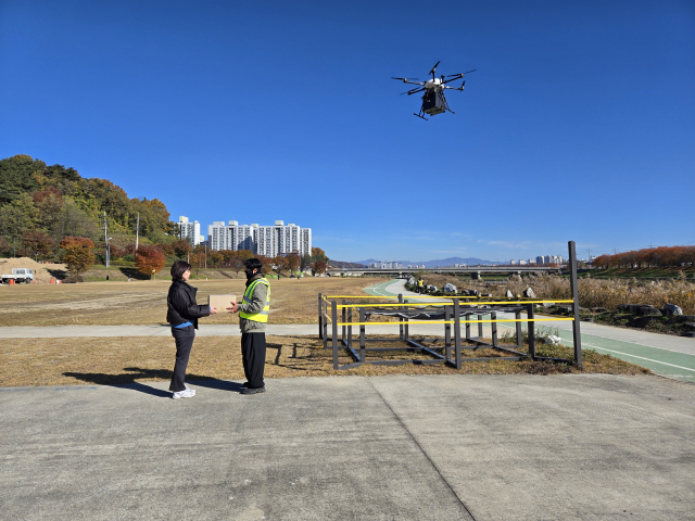안전요원이 문정둔치로 드론배송 된 물건을 찾아 주문한 고객에게 전달하고 있다. 마경대 기자