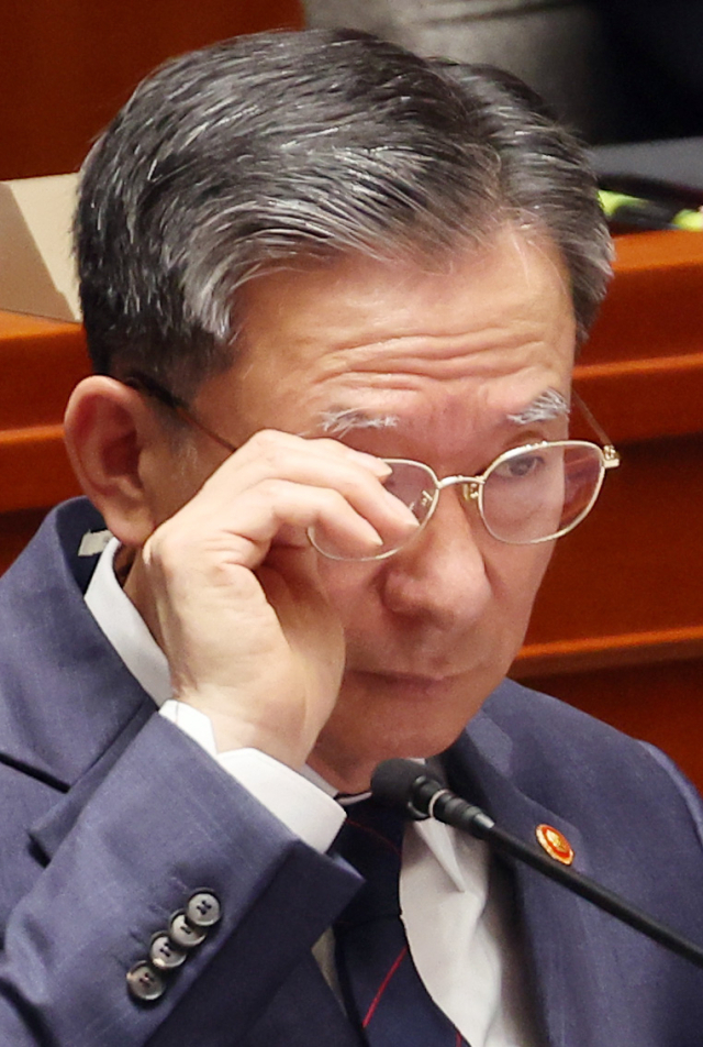 정성호 법무부 장관이 12일 국회에서 열린 예산결산특별위원회 전체회의에 출석해 안경을 고쳐쓰고 있다. 연합뉴스