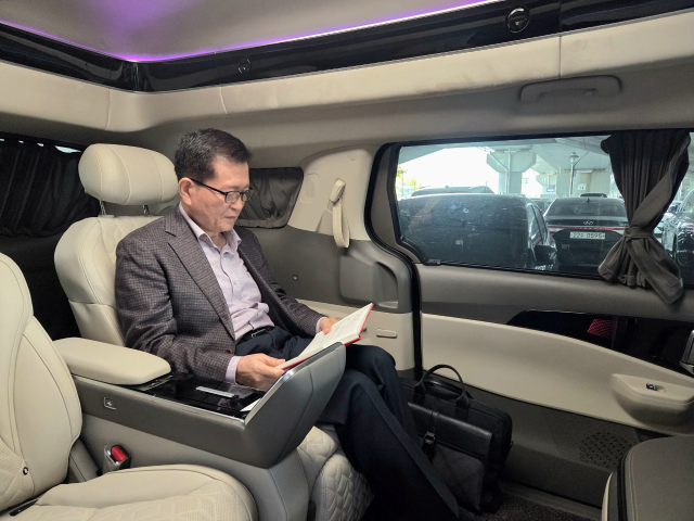 출장객 민병률씨가 구미상공회의소 의전차량에 탑승해 회사에서 할 업무를 미리 파악하고 있다. 조규덕 기자