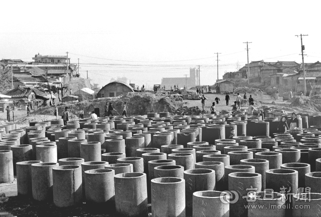 1973년 11월 대구 대서로(현 달구벌대로) 확장공사 현장에 놓인 콘크리트 하수관. 멀리 대구 서현교회 건물이 보인다. 매일아카이빙센터