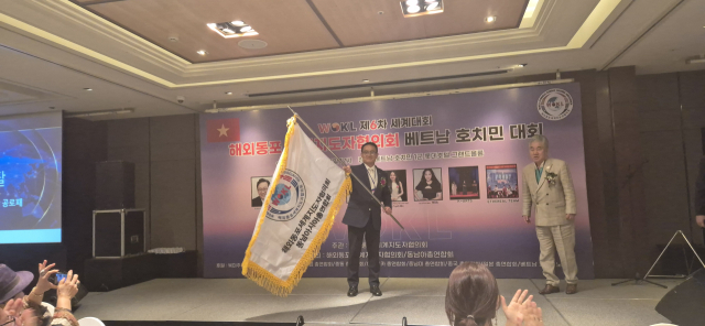 황의훈 호치민 한인회장이 아시아 총회장으로 공식 추대되어, 총회 깃발을 흔들고 있다. 세계지도자협의회 제공