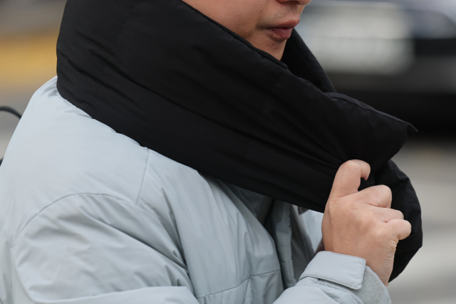 서울 아침 기온이 2도까지 떨어지며 추운 날씨를 보인 17일, 서울 종로구 광화문네거리에서 한 시민이 목도리를 착용하고 있다. 연합뉴스