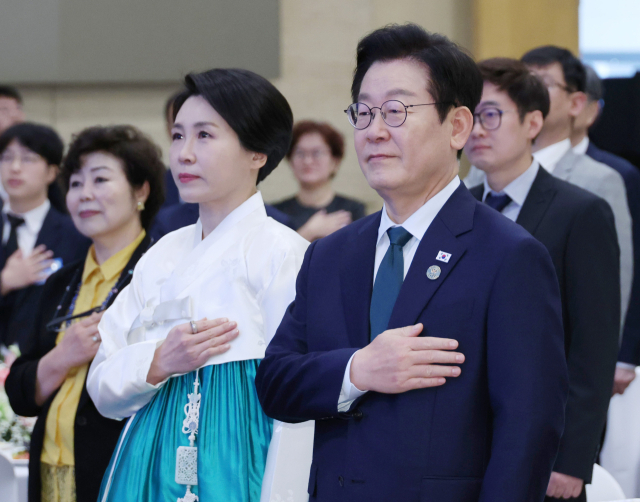 이재명 대통령과 김혜경 여사가 23일(현지시간) 남아프리카공화국 요하네스버그 샌튼 컨벤션센터에서 열린 동포 오찬간담회에서 참석자들과 국기에 경례하고 있다. 연합뉴스