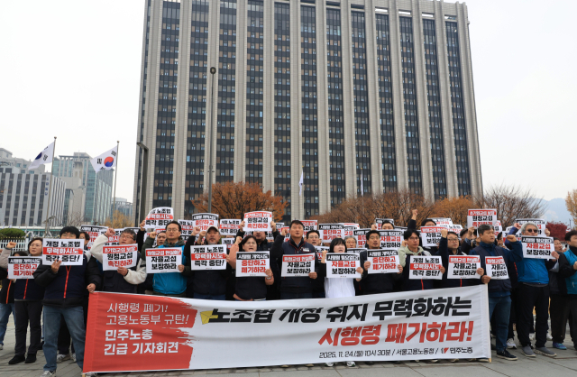 양경수 전국민주노동조합총연맹 위원장을 비롯한 노동조합 관계자들이 24일 정부서울청사 앞에서 노동부가 발표할 개정 노조법 시행령 관련 긴급 기자회견을 열고 구호를 외치고 있다. 연합뉴스