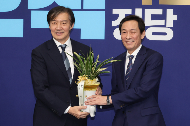 우상호 대통령실 정무수석이 25일 서울 여의도 국회에서 조국혁신당 조국 신임 대표를 예방해 이재명 대통령의 축하난을 전달하고 있다. 연합뉴스