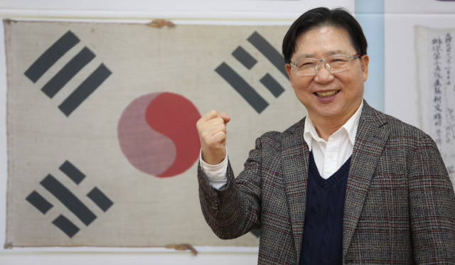 독도가수 서희 씨가 조양회관 2층 강당에서 태극기 사진을 배경으로 