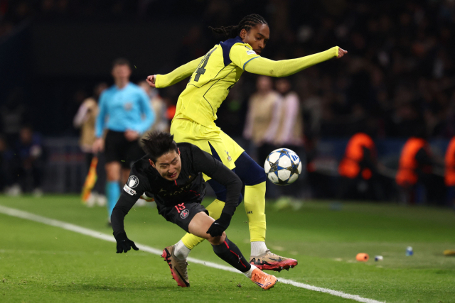 PSG의 이강인이 27일 프랑스 파리의 파르크 데 프랭스에서 열린 UEFA 챔피언스리그 리그 페이즈 5라운드 경기 도중 토트넘의 제드 스펜스에게 밀려 넘어지고 있다. 연합뉴스