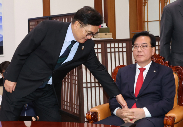 우원식 국회의장이 27일 서울 여의도 국회에서 열린 국회의장 주재 여야 교섭단체 원내대표 회동에서 기념 촬영을 거부하는 국민의힘 송언석 원내대표에게 참여를 권하고 있다. 연합뉴스