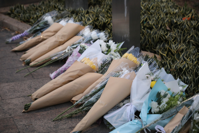 28일(현지시간) 대형 화재가 발생한 홍콩 북부 타이포의 고층 아파트 단지 웡 푹 코트 인근 공원에 추모객들이 두고 간 꽃다발이 놓여있다. 연합뉴스