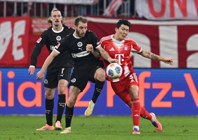 바이에른 뮌헨의 김민재가 29일 독일 뮌헨의 알리안츠 아레나에서 열린 분데스리가 경기 도중 FC장크트 파울리의 라르스 리츠카와 공을 다투고 있다. 연합뉴스