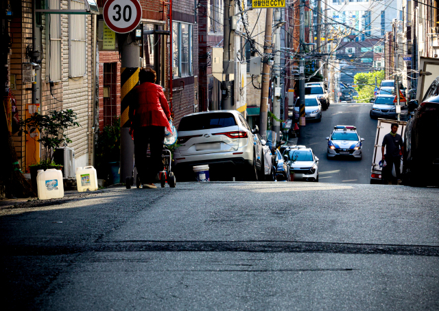 대구 남구 대명동 어느 노후주택가의 조용한 골목. 한 노인이 보행기보조기를 끌며 걸어가고 있다. 안성완 기자 asw0727@imaeil.com