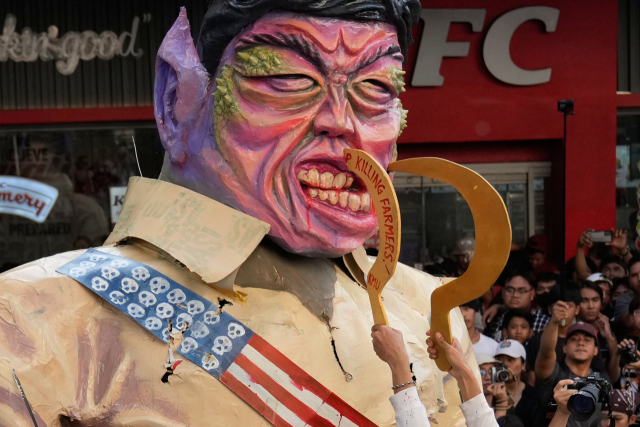 11월 30일(현지시간) 필리핀 마닐라에서 열린 집회에서 시위대가 페르디난드 마르코스 주니어 필리핀 대통령의 얼굴을 희화화한 인형을 앞세워 행진하고 있다. AP 연합뉴스