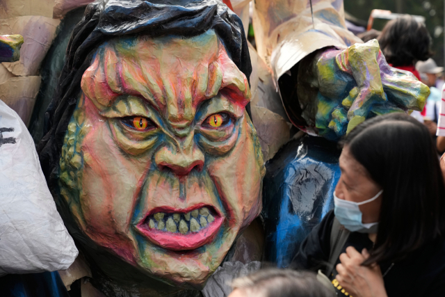 11월 30일(현지시간) 필리핀 마닐라에서 열린 시위에서 한 시위자가 필리핀 부통령 사라 두테르테(로드리고 두테르테 전 필리핀 대통령의 딸)의 얼굴을 본뜬 가면을 쳐다보고 있다. AP 연합뉴스
