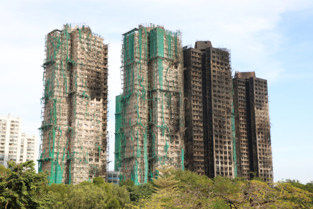 28일(현지시간) 홍콩 북부 타이포의 고층 아파트 단지 웡 푹 코트에서 난 불이 완전히 꺼지고 그을음이 남은 모습. 타다 만 안전그물과 대나무 비계가 건물에 붙어있다. 연합뉴스