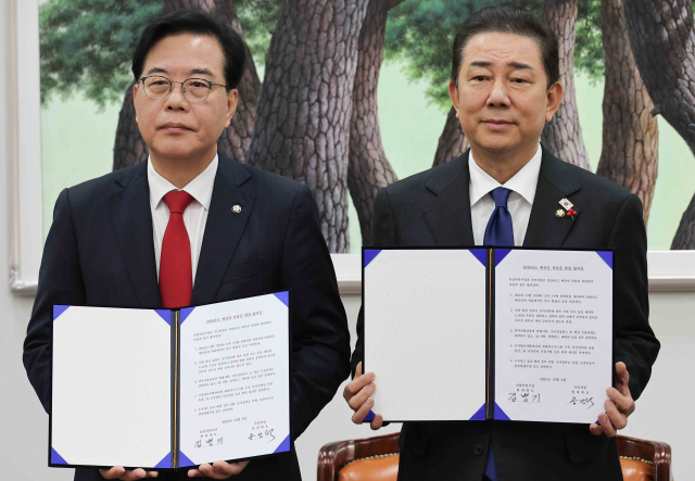 국민의힘 송언석 원내대표(왼쪽)와 더불어민주당 김병기 원내대표가 2일 서울 여의도 국회에서 2026년도 예산안 처리를 위한 합의문에 서명을 마치고 기념 촬영하고 있다. 연합뉴스