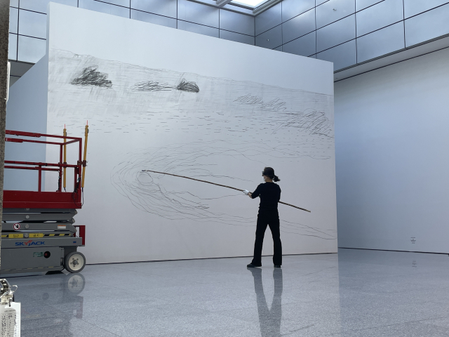허윤희 작가가 지난달 전시 개막식에서 목탄 작업 퍼포먼스를 펼치고 있다. 이연정 기자