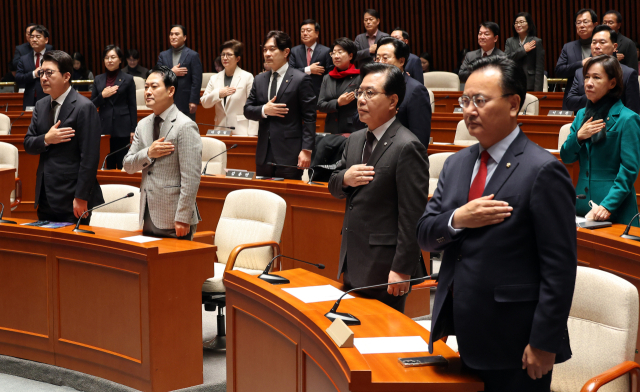 장동혁 대표와 송언석 원내대표를 비롯한 국민의힘 의원들이 8일 국회에서 열린 의원총회 및 이재명 정권 독재악법 국민고발회에서 국기에 경례하고 있다. 연합뉴스