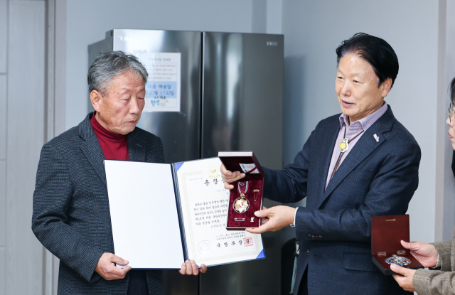 고(故) 이득기 상병의 화랑무공훈장을 이병환 성주군수가 고인의 아들인 이종호 씨에게 전달하고 있다. 성주군 제공