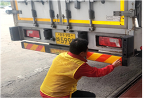 중부내륙 하행선 문경주유소 관계자가 야간 주행 시 화물차 식별성을 높이기 위해 반사 스티커를 이용객 차량에 부착하고 있다.