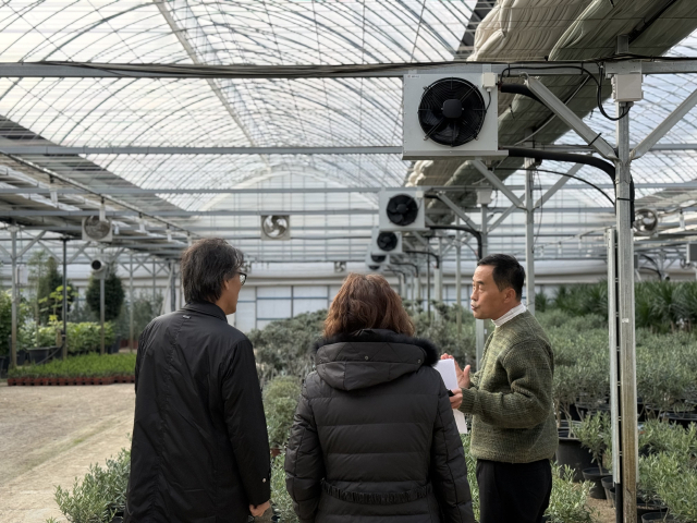 금한승 기후에너지환경부 1차관이 지난달 26일 경기 안성시 농가에서 지열-공기열 히트펌프를 활용한 관엽식물 재배 현장을 살펴보고 있다. 연합뉴스