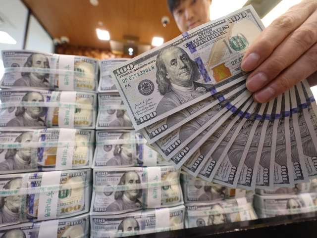 원/달러 환율 고공행진으로 시장의 우려가 커지는 가운데 외환 당국과 국민연금은 연간 650억달러 규모의 외환스와프(FX Swap) 계약을 1년 연장하기로 지난 15일 합의했다. 16일 서울 중구 하나은행 위변조대응센터에서 직원이 달러화를 정리하고 있다. 연합뉴스
