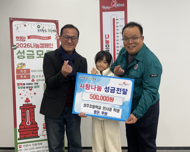 성주초등학교 1학년 민서경 학생이 자신이 모은 용돈과 할아버지의 성금을 합한 기부금을 전달하고 있다. 성주군 제공