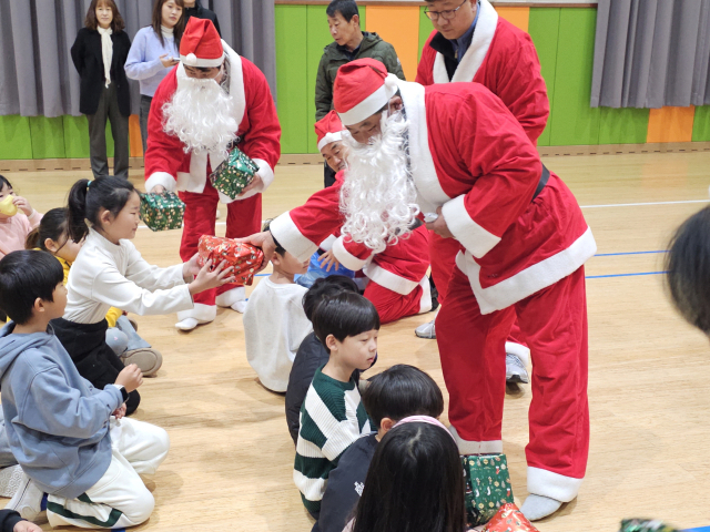 문경읍 지역사회보장협의체 위원들이 성탄절을 앞둔 지난 18일 산타클로스로 변신, 지역 어린이들에게 선물을 나눠주고 있다. 문경읍 제공