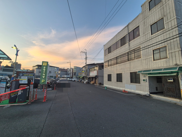 지난 22일 대구 서구 서부시장공영주차장을 마주한 빌딩 모습. 최근 주차장 진출 차량이 건물을 들이받는 사고로 문 한 쪽이 파손된 상태다. 김지수 기자