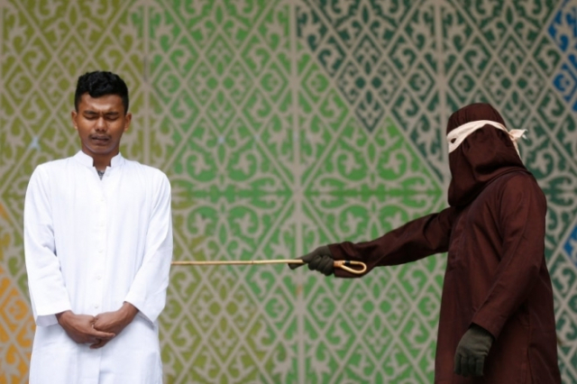 4일(현지시간) 인도네시아 아체주 반다아체에 있는 공원에서 한 남성이 혼외 성관계를 했다는 이유로 공개 태형을 받고 있다. 2025.6.4 EPA 연합뉴스