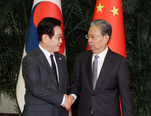중국을 국빈방문 중인 이재명 대통령이 6일 베이징 인민대회당에서 국회의장 격인 자오러지 전국인민대표대회 상무위원장과 악수하고 있다. 연합뉴스