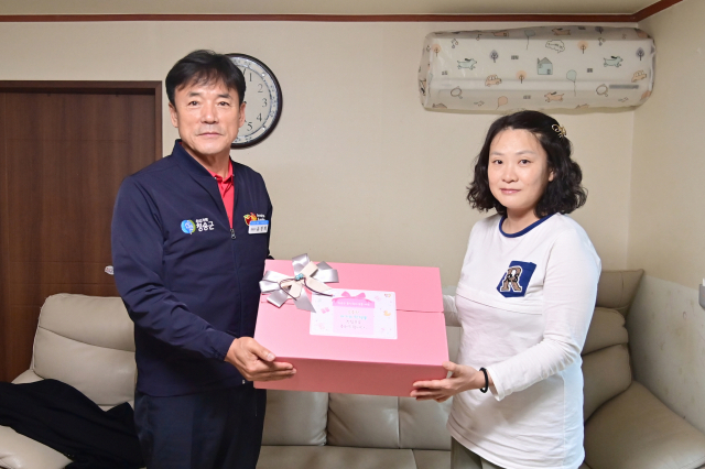 윤경희(사진 왼쪽) 청송군수가 최근 여섯째 아이를 출산한 김주환(48)·권선예(42) 씨 부부의 가정을 찾아 축하 인사를 전했다. 사진은 선예 씨가 윤 군수의 선물을 받는 모습. 청송군 제공