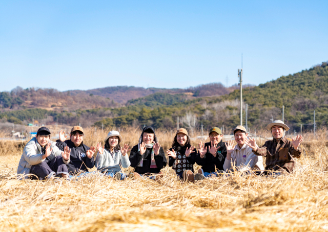 (왼쪽부터)영천 청년농부 하성호, 박해원, 전혜영, 정영빈, 장나은, 김원섭, 노구완, 한종호 씨가 들녘에 앉아 손을 흔들고 있다.