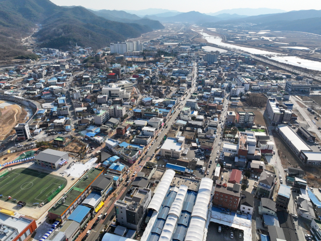 경북 군위군이 대구시로 편입된 지 2년 6개월이 지나면서 인사, 재정, 교통, 행정 등 다양한 영역에서 명암이 엇갈리고 있다. 군위읍 상공에서 바라본 전경. 군위군 제공.