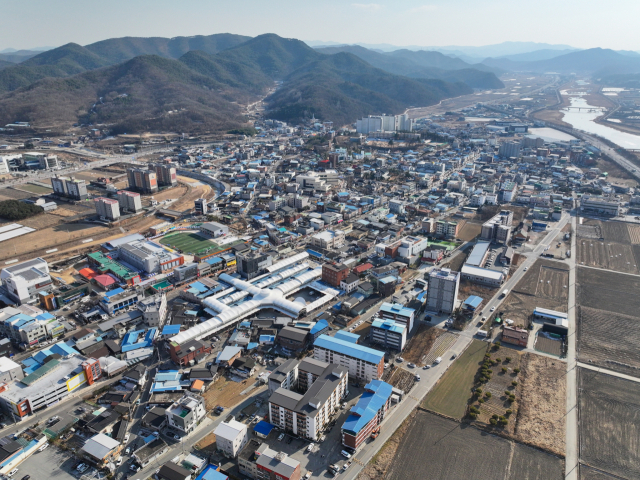 경북 군위군이 대구시로 편입된 지 2년 6개월이 지나면서 인사, 재정, 교통, 행정 등 다양한 영역에서 명암이 엇갈리고 있다. 군위읍 상공에서 바라본 전경. 군위군 제공.