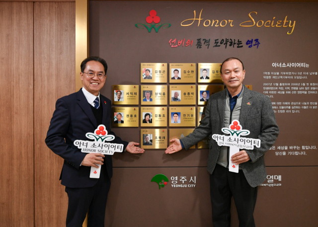 조욱래 대표(오른쪽)가 아너소사이어티 회원으로 등재 됐다. 등재 된 동판앞에서 기념사진을 촬영했다. 영주시 제공