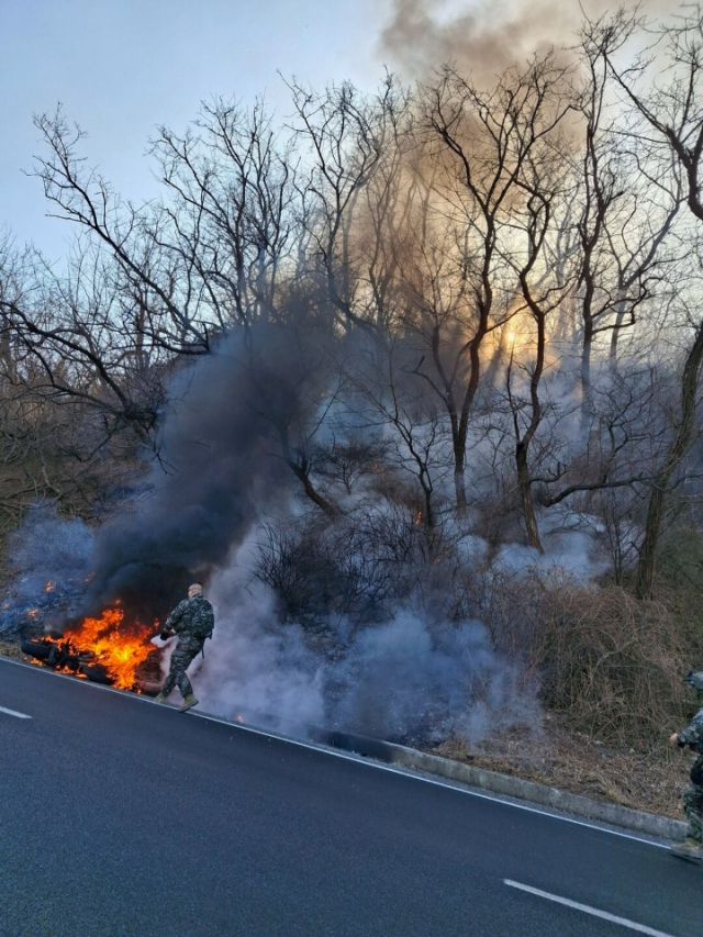 지난 15일 오후 1시 48분쯤 포항시 남구 장기면 대진항 인근 도로에서 발생한 오토바이 화재가 야산으로 번지는 것을 김현준 상사가 진화하고 있다. 포항남부소방서 제공.