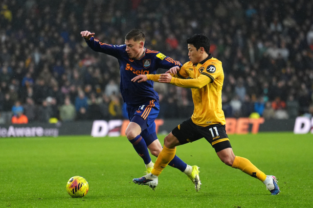 울버햄튼의 황희찬이 18일 영국 울버햄튼의 몰리뉴 스타디움에서 열린 EPL 22라운드 경기 도중 뉴캐슬의 하비 반즈와 공을 다투고 있다. AP 연합뉴스